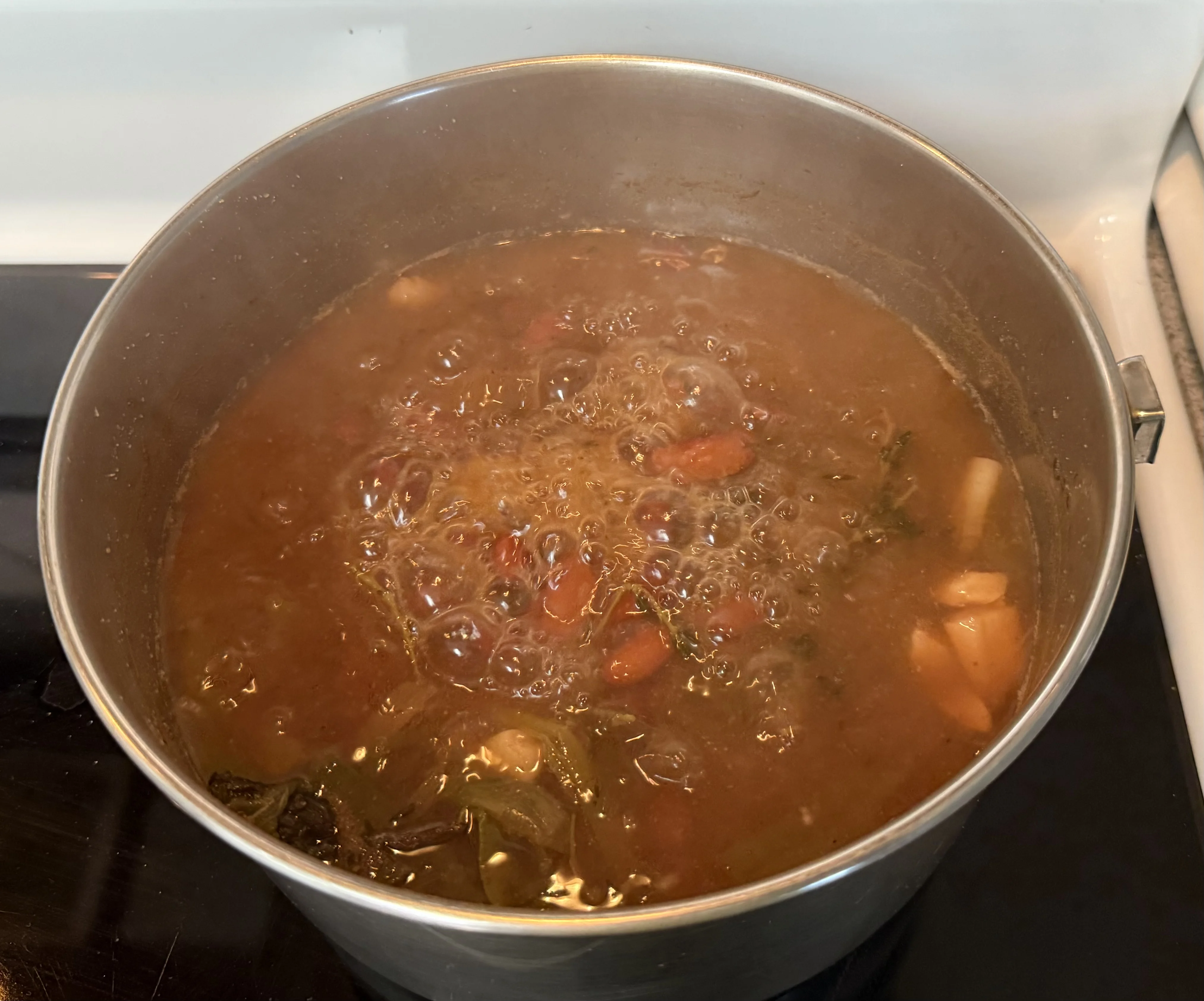 A pot of red kidney beans boiling with scallion and thyme